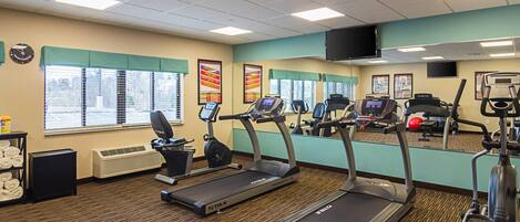 A gym with treadmills, exercise bikes, and a weight machine.