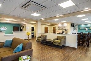 A reception area with a counter, seating, and a coffee station. - Suburban Studios Monaca - Pittsburgh (Monaca)