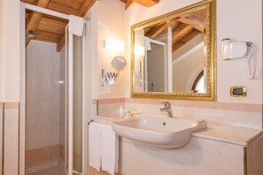 A bathroom with a white sink, a large mirror with a gold frame, a towel rack, and a shower area. - Albergo Villa Priula (Sorisole)