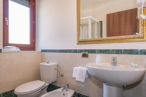 A bathroom with a toilet, sink, and mirror. - Albergo Villa Priula (Sorisole)