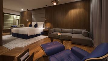 Una habitación de hotel moderna con una cama grande, un sofá, una mesita de café y un escritorio.
