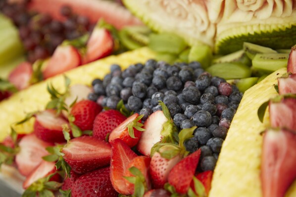 Una variedad de frutas frescas, como fresas, arándanos y kiwi, dispuestas sobre una mesa.