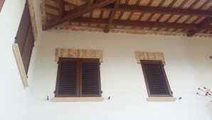 A building with a wooden ceiling structure and two windows with shutters. - I Tufi (Colonnella)