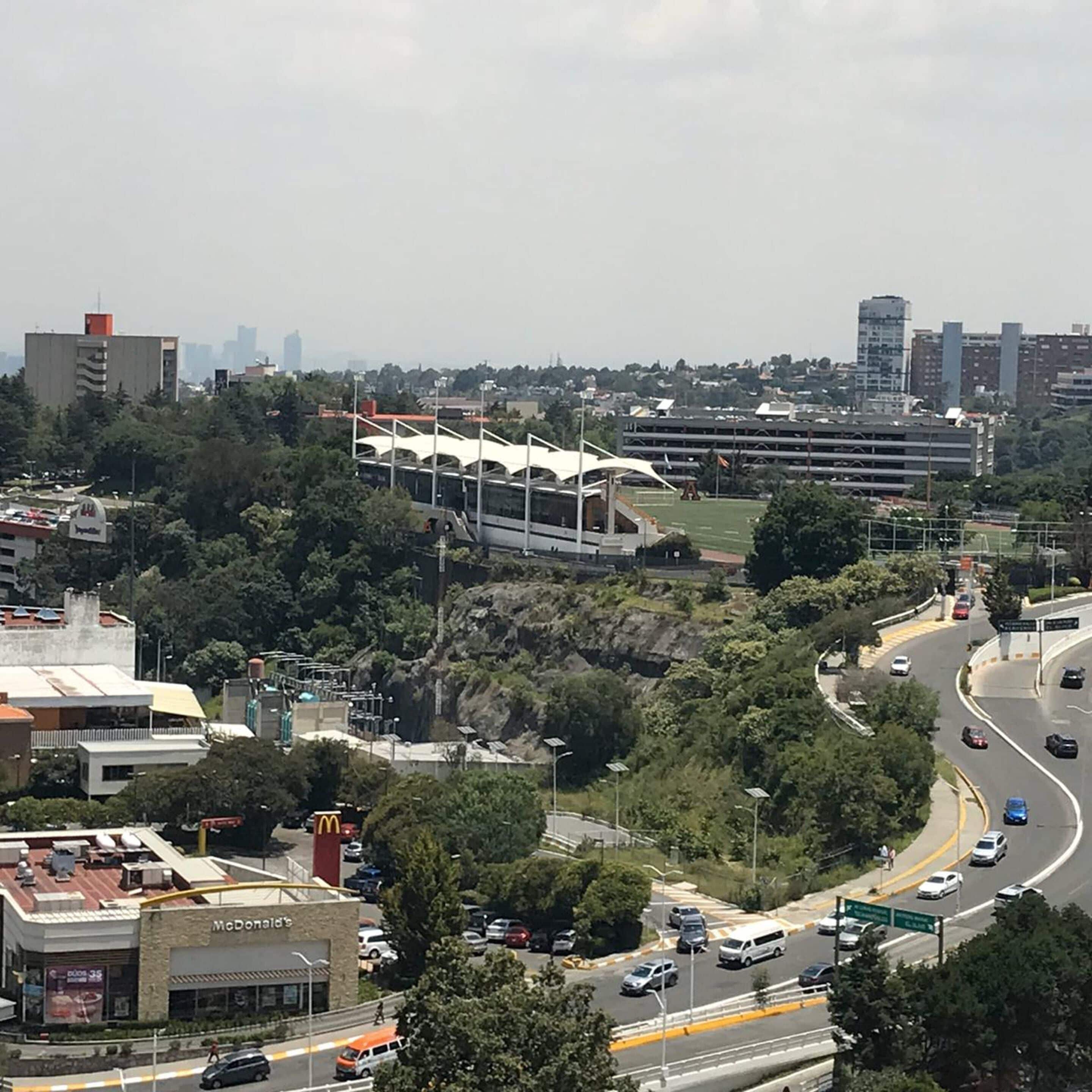 Um restaurante McDonald's com estacionamento e uma estrada com veículos.