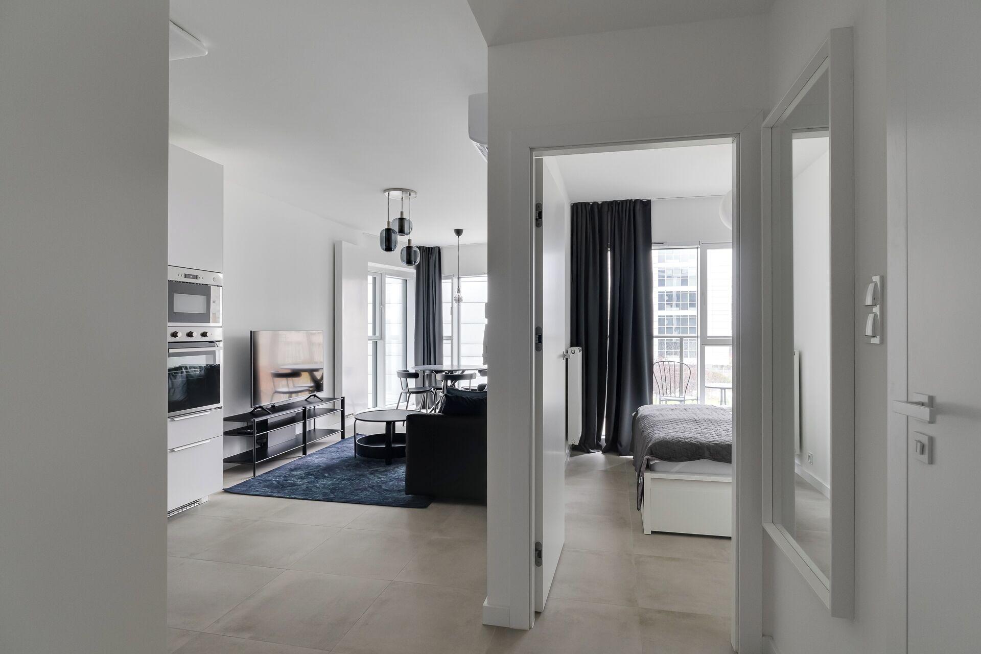 Ein modernes Hotelzimmer mit einer Küchenzeile, einem Essbereich und einem Bett.