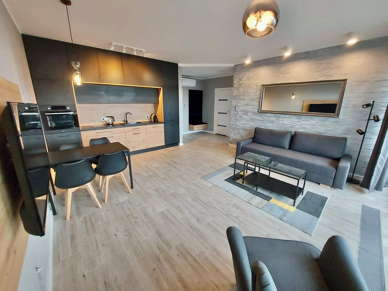 A modern living space with a kitchen, dining area, and seating area.