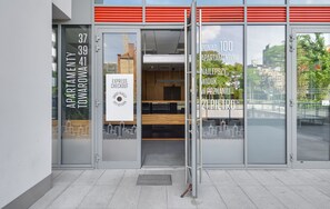 Ein modernes Gebäude mit Glasfassade, Blick auf die Stadt und einem Schild für einen Express-Check-out.