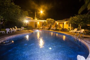 A swimming pool with lounge chairs and a building in the background. - Hotel La Punta (Puntarenas)