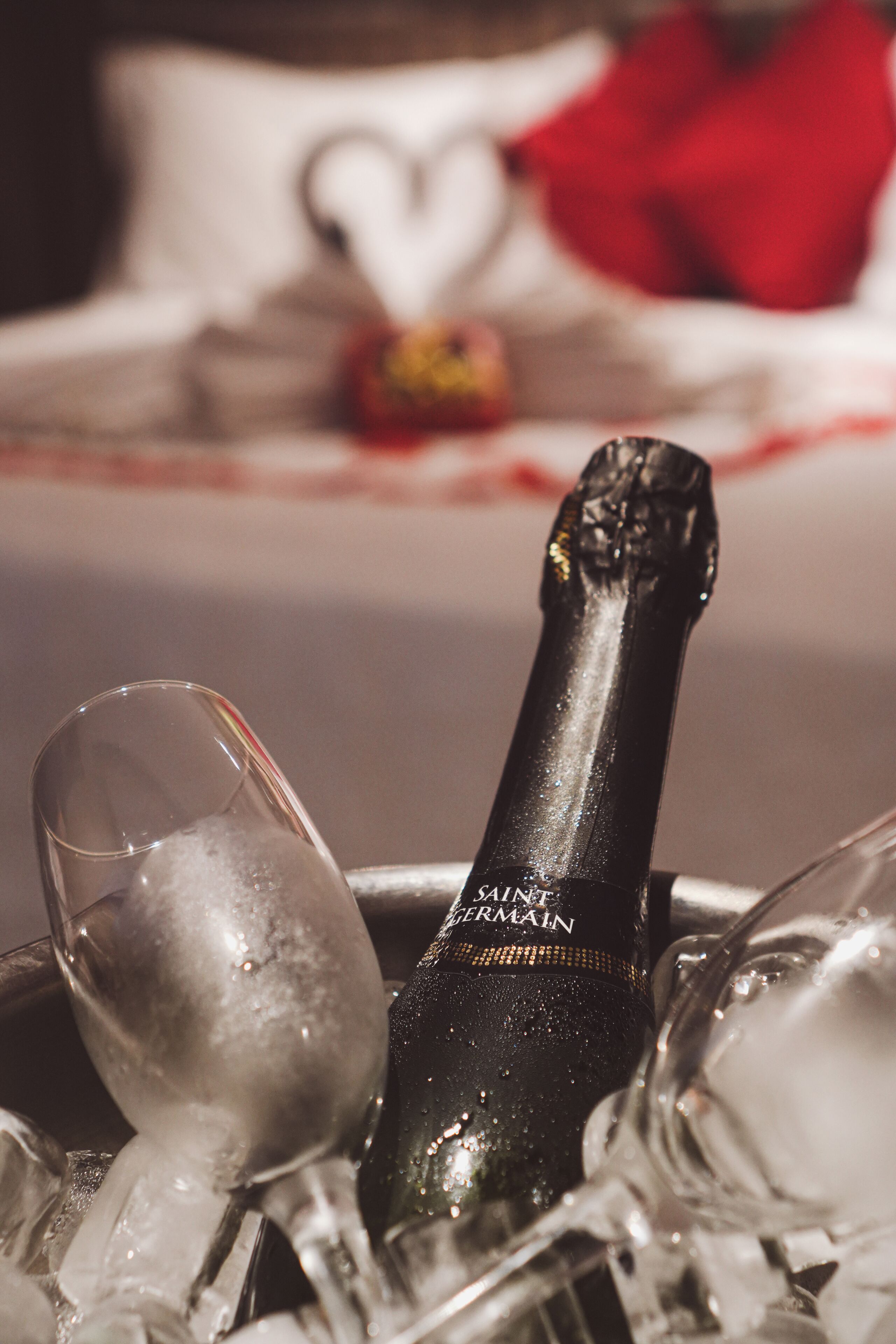 Champagnefles in een glazen houder met ijsblokjes.
