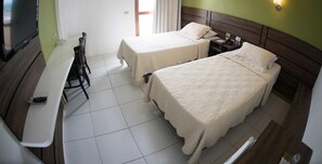 A hotel room with two beds, a desk, and a TV. - Panorama Hotel (Juazeiro do Norte)