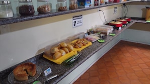 A buffet counter with various food items and condiments. - Pousada Aconchego (Juazeiro do Norte)