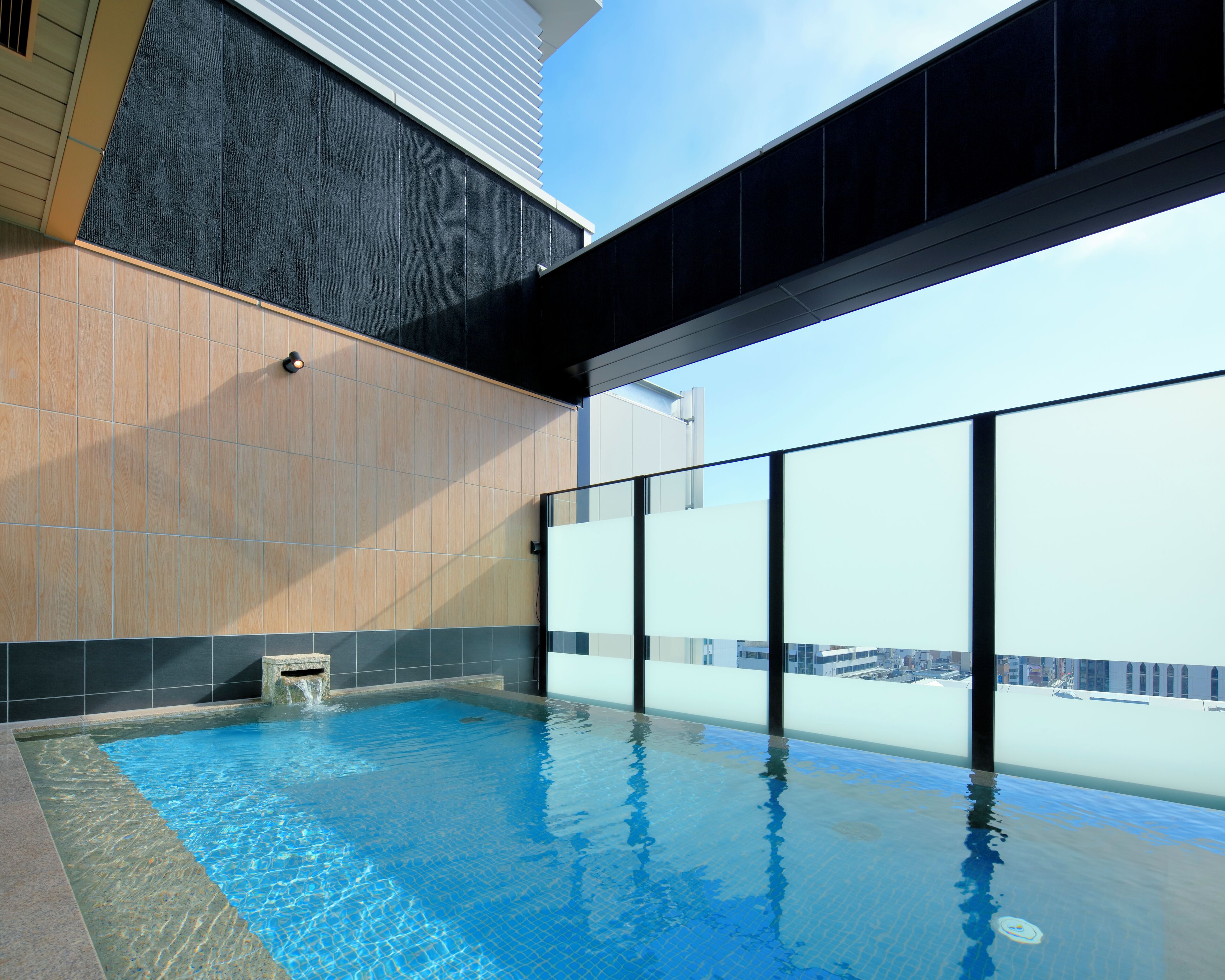 A modern indoor swimming pool with a view of the city skyline.