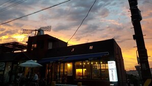 Un bâtiment avec une enseigne indiquant « Café » et un grand parasol à l’extérieur.
