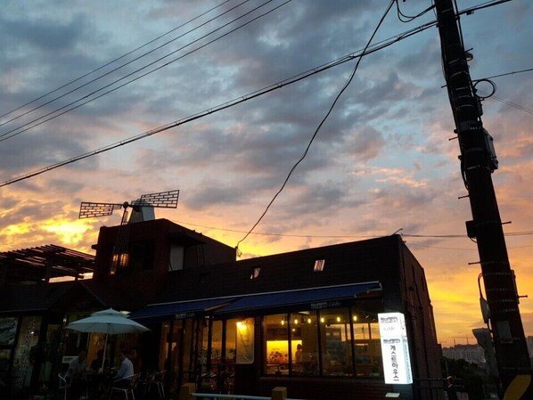 A building with a sign that reads "Cafe" and a large umbrella outside. - Mokpo White Windmill Guesthouse (Mokpo)