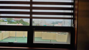 Une fenêtre à carreaux multiples, chacun offrant une vue sur un quartier résidentiel avec des immeubles et de la verdure.