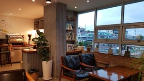 Un café acogedor con pared de ladrillo, una máquina de café y un amplio ventanal con vistas a la ciudad.