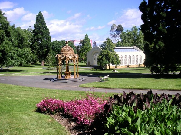 A gazebo in a park with a building in the background. - Parklane Motel (Launceston)