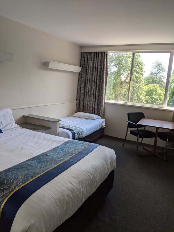 A hotel room with two beds, a desk, and a chair. - Parklane Motel (Launceston)