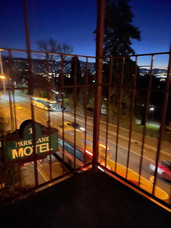 A view of a street at dusk with a motel sign visible.