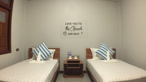 A hotel room with two beds, each with a striped pillow, a small wooden nightstand between them, and a wall sign that reads "Love you to the beach and back." - WEStay @ Chillax House - Ngapali - Hostel (Ngapali)