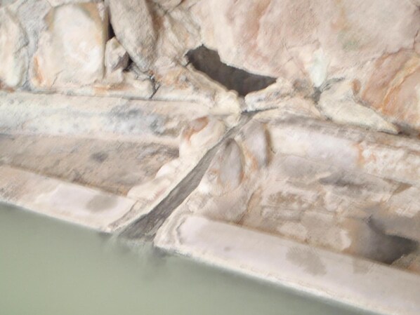 Un primer plano de una pared de piedra con un hueco, quizás un nicho o alcova.