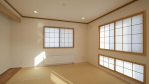 Quarto com piso de tatame, amplas portas shoji e radiador.