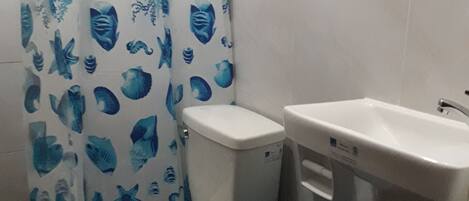 Ein Badezimmer mit Toilette, Waschbecken und einer blauen Mülleimer.