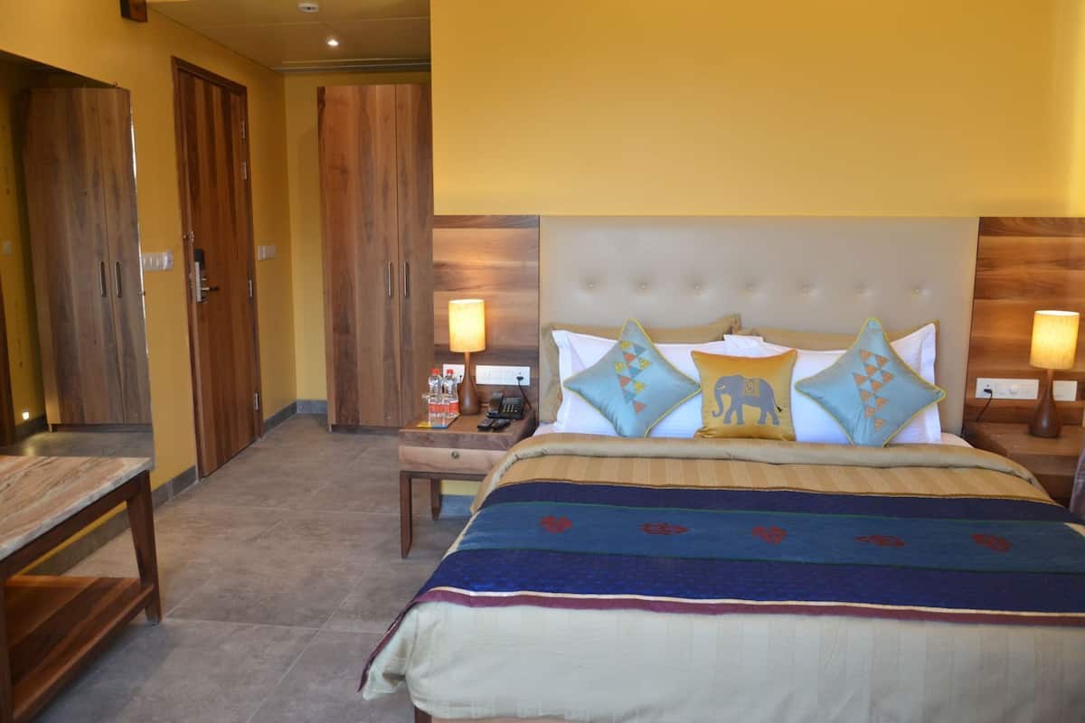 A hotel room with a bed, bedside tables, a nightstand, a desk, and two wardrobes.