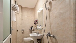 Moderni kylpyhuone, jossa on suihku, pesuallas ja wc.