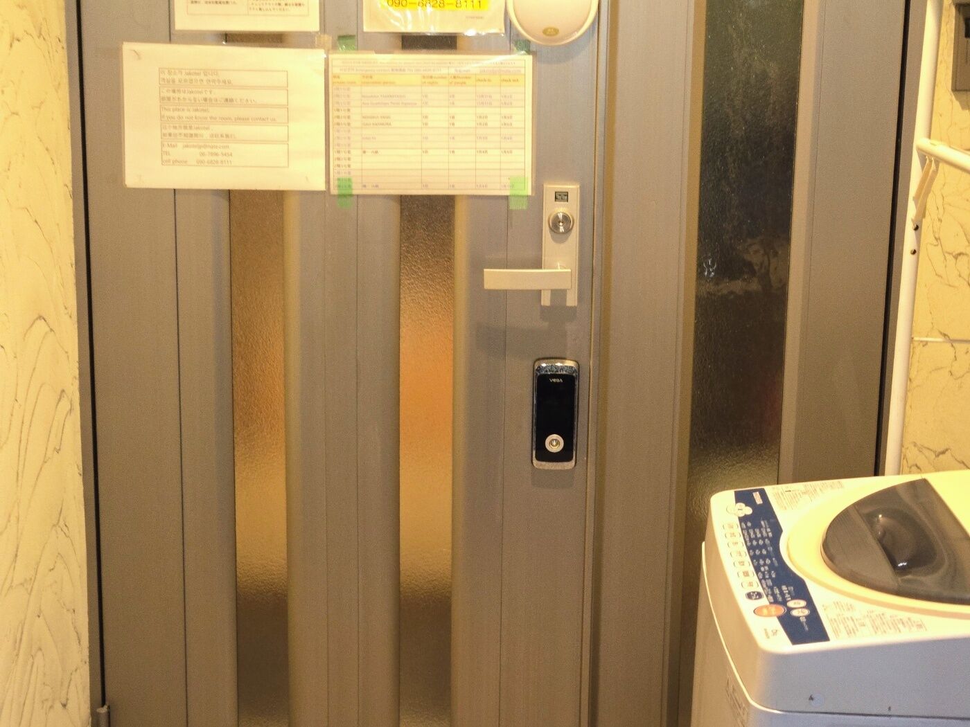 An elevator with a control panel, a phone, and a laundry machine.