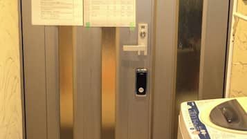 An elevator with a control panel, a phone, and a laundry machine.