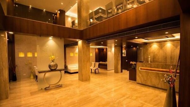 A spacious lobby with a marble floor, a reception desk, and a seating area. - The Maureen (Barasat)