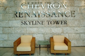 A sign for Chevron Renaissance Skyline Tower with two wicker chairs and a small table in front.