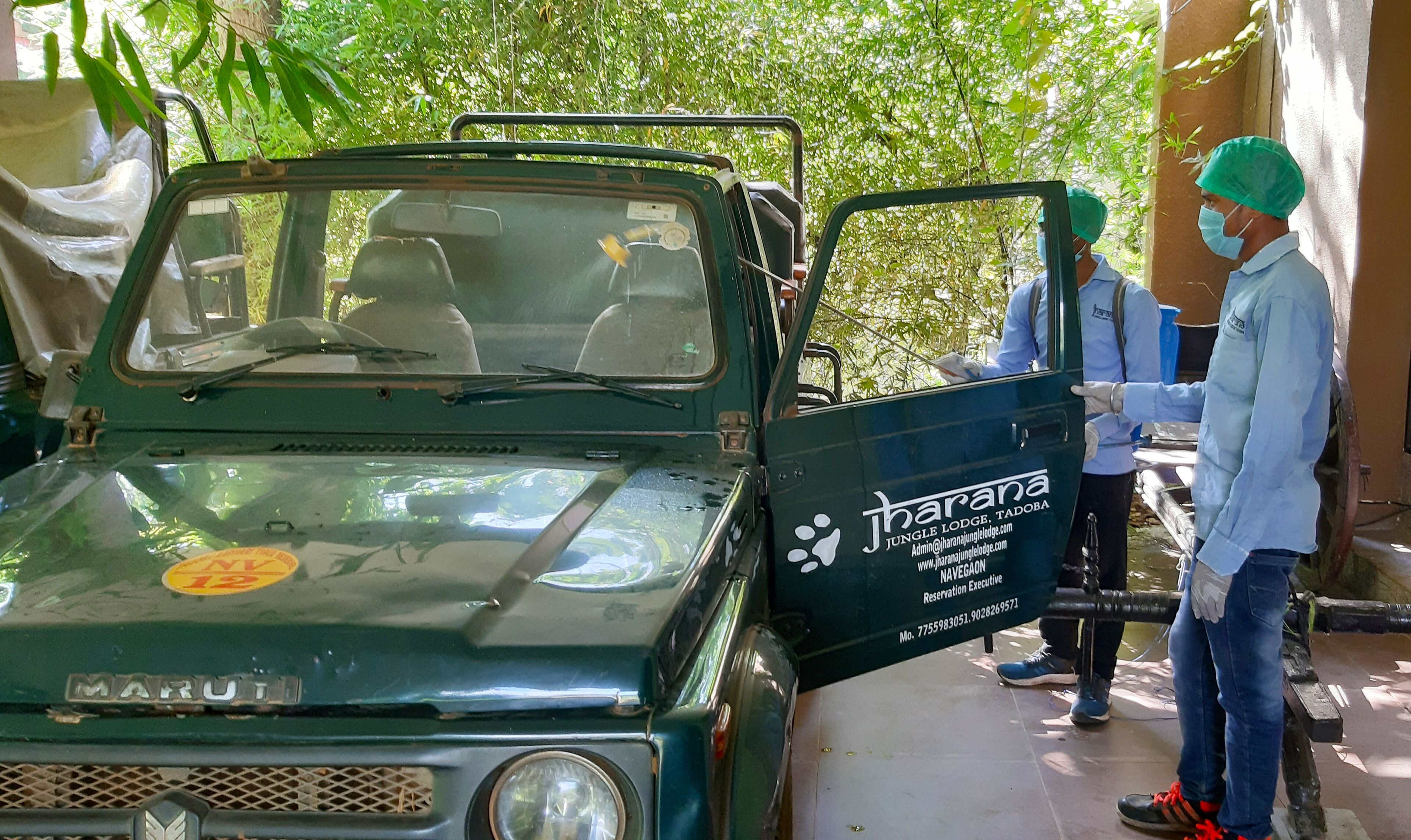 Un vehículo verde Maruti con un anuncio de Jungle Lodge en la carrocería.