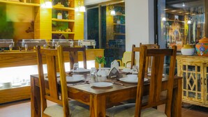 Un comedor con muebles de madera, un expositor de vidrio y una ventana con vistas al exterior.
