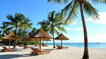 Plage, sable blanc, chaises longues, parasols