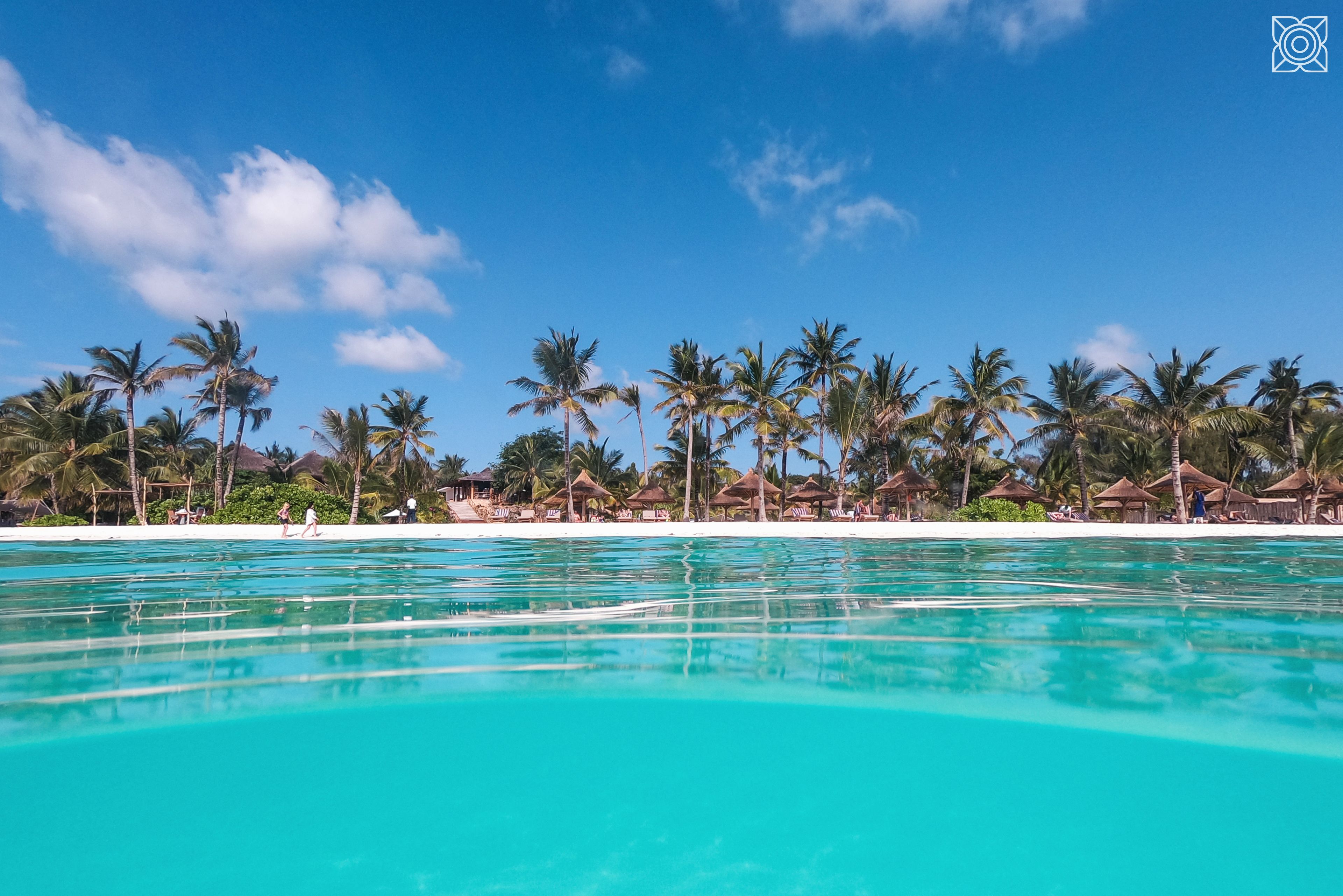 En la playa, playa de arena blanca, camastros y sombrillas 
