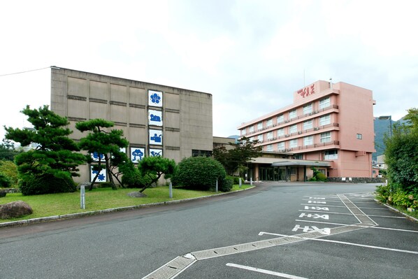 A parking lot with marked spaces and a building with a signboard.