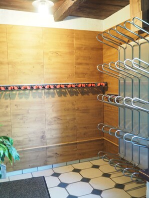 Ein Zimmer mit Holzboden, einer Fliesenfläche, einem Metallgestell und einer Deckenleuchte.