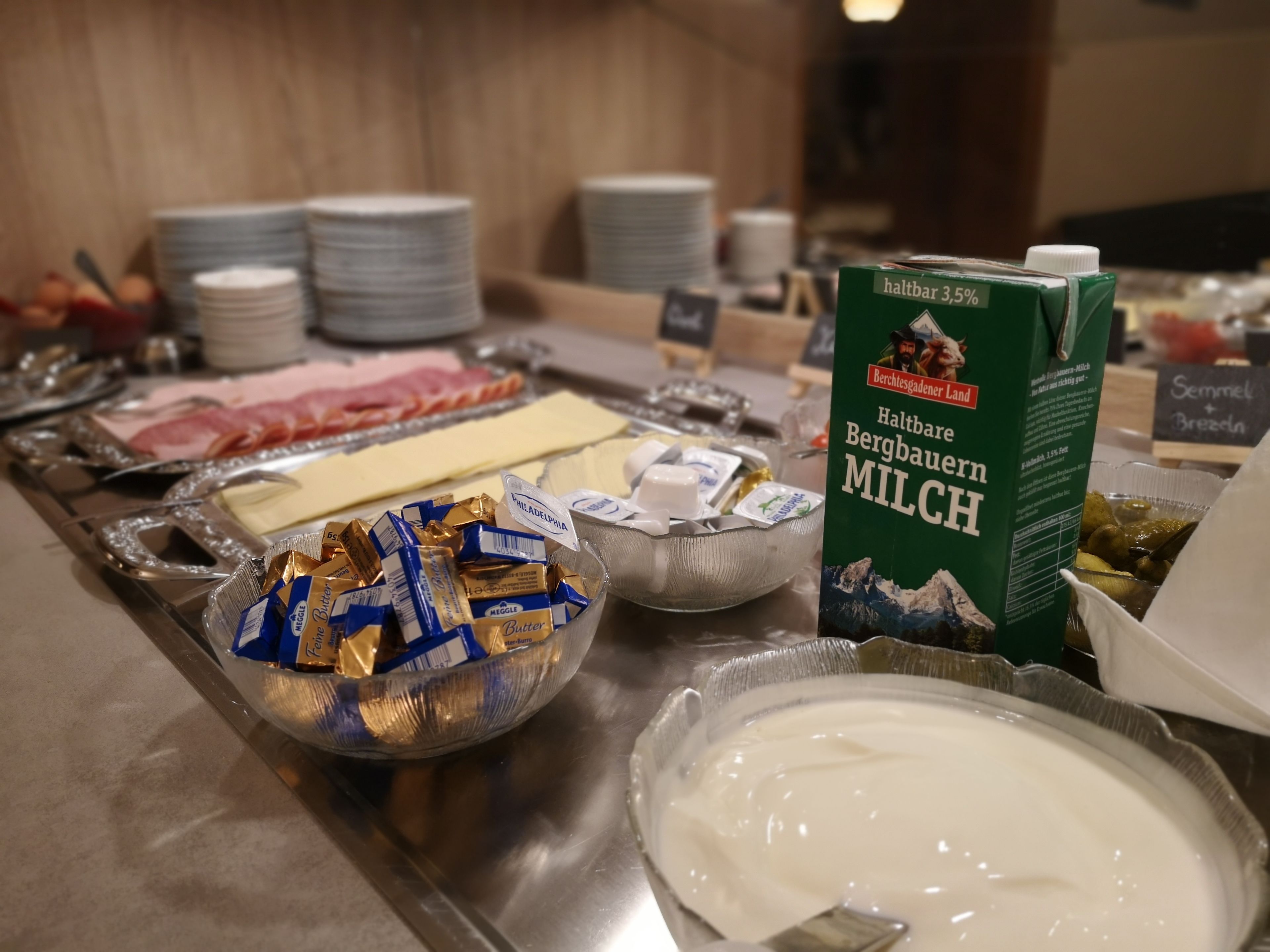 Un buffet proposant une variété d’aliments, notamment du fromage, du beurre et du lait.