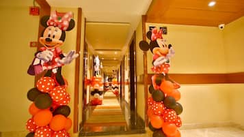 A hotel corridor with Mickey Mouse decorations and a red carpet.