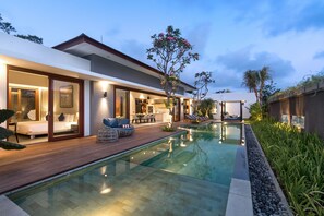 Una casa moderna con piscina, un dormitorio con ventana grande y un comedor.
