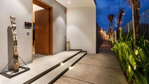 A modern hotel entrance with a wooden door, a sign indicating room number 01, and a pathway leading to the building. - Amarin Seminyak (Seminyak)