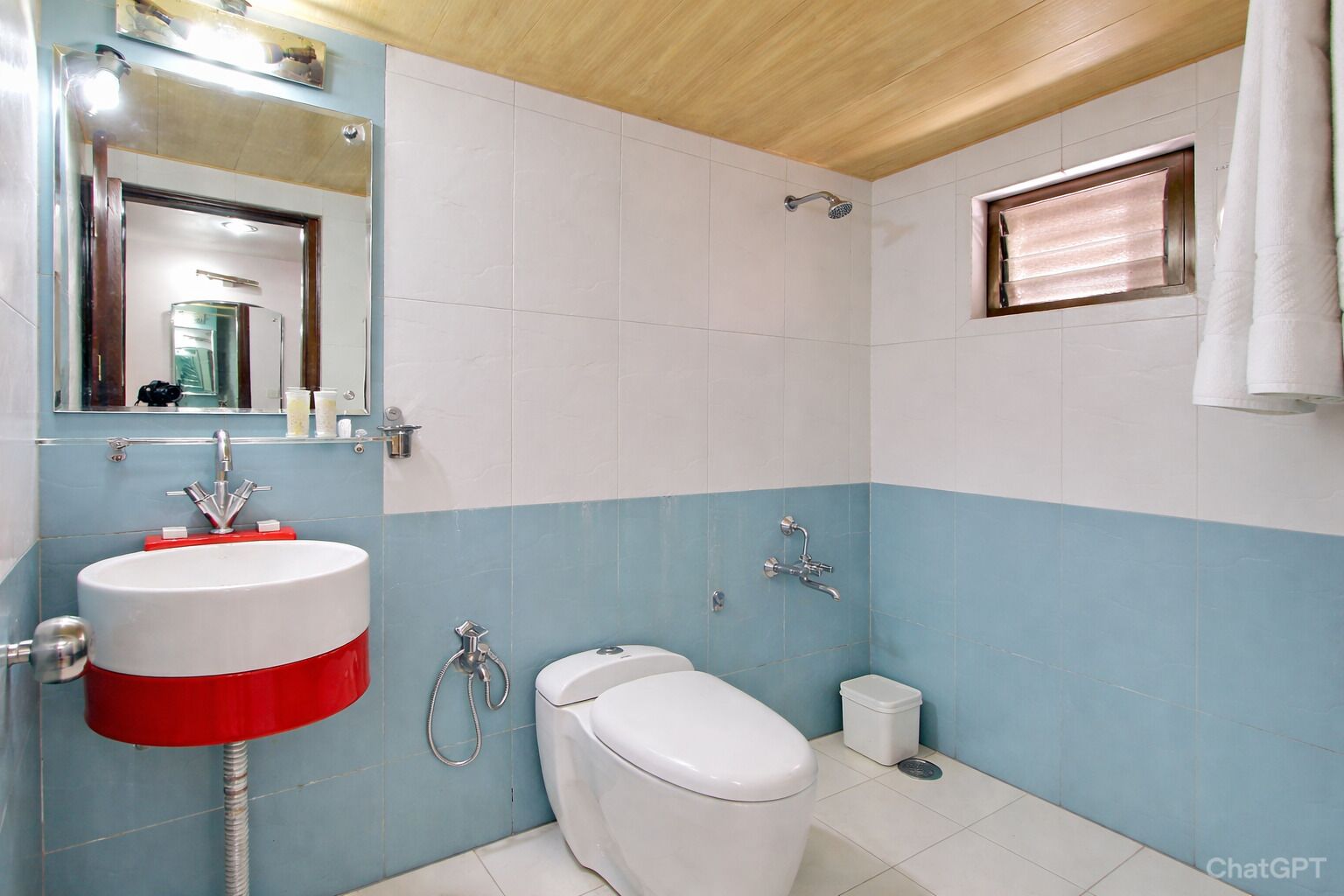 Un baño con lavamanos blanco, inodoro, ducha y espejo.