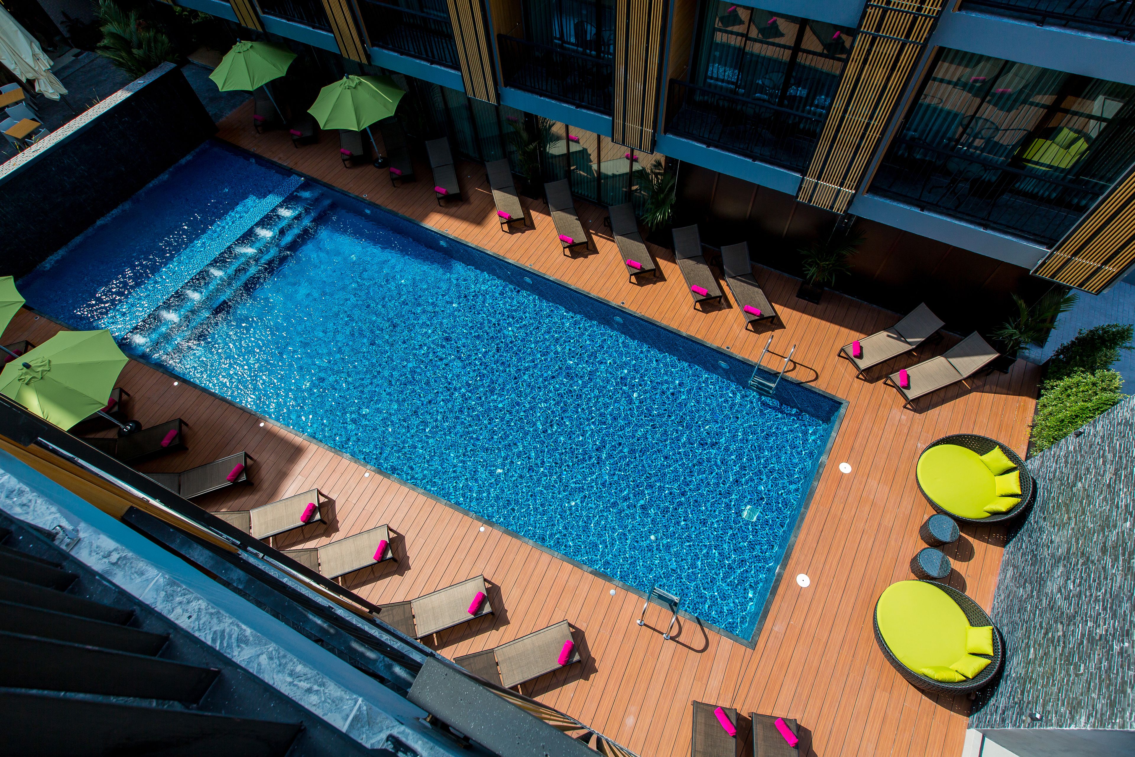Une piscine extérieure dotée de chaises longues et de parasols.