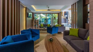 Una sala de estar moderna con sofás azules y grises, una mesa de centro de madera y vistas al área exterior.