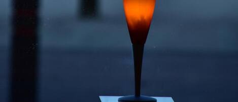 A glass of drink on a table with a blurred background of a person walking.