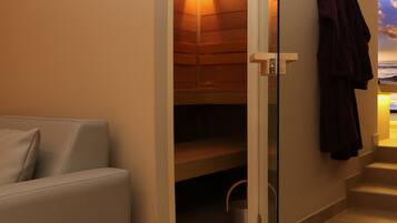 Una sala de sauna con paredes de madera, un banco y toallas colgadas en la pared.