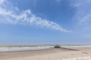 A beach with a pier extending into the ocean, a sandy beach, and a clear sky. - Hotel Riant Séjour by WP Hotels  (Blankenberge)