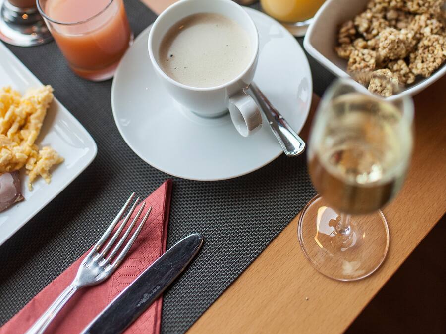 A breakfast table with various dishes including eggs, toast, and a glass of orange juice.